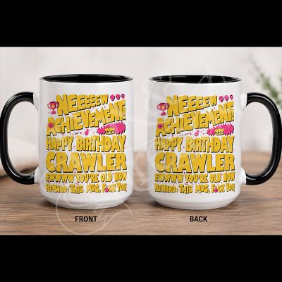 New Achievement Happy Birthday Crawler 15 oz white mug with black handle and pink and yellow artwork